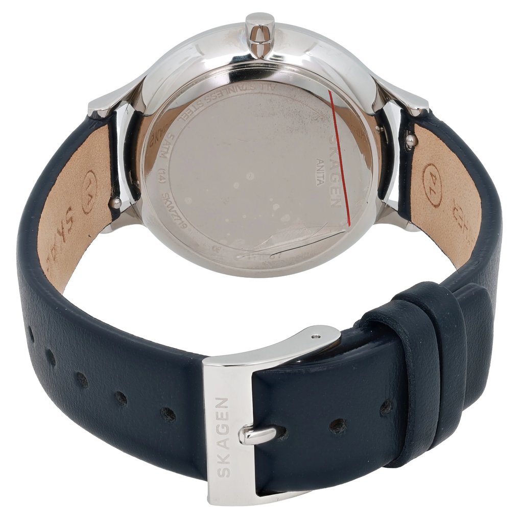 An image of a women's Skagen wristwatch viewed from the back at a slight angle, showcasing the watch's case and leather strap. The watch is positioned at a moderate distance, highlighting the silver buckle engraved with the brand name. The back casing is reflective with visible text and a red line, indicative of the new condition with defects.