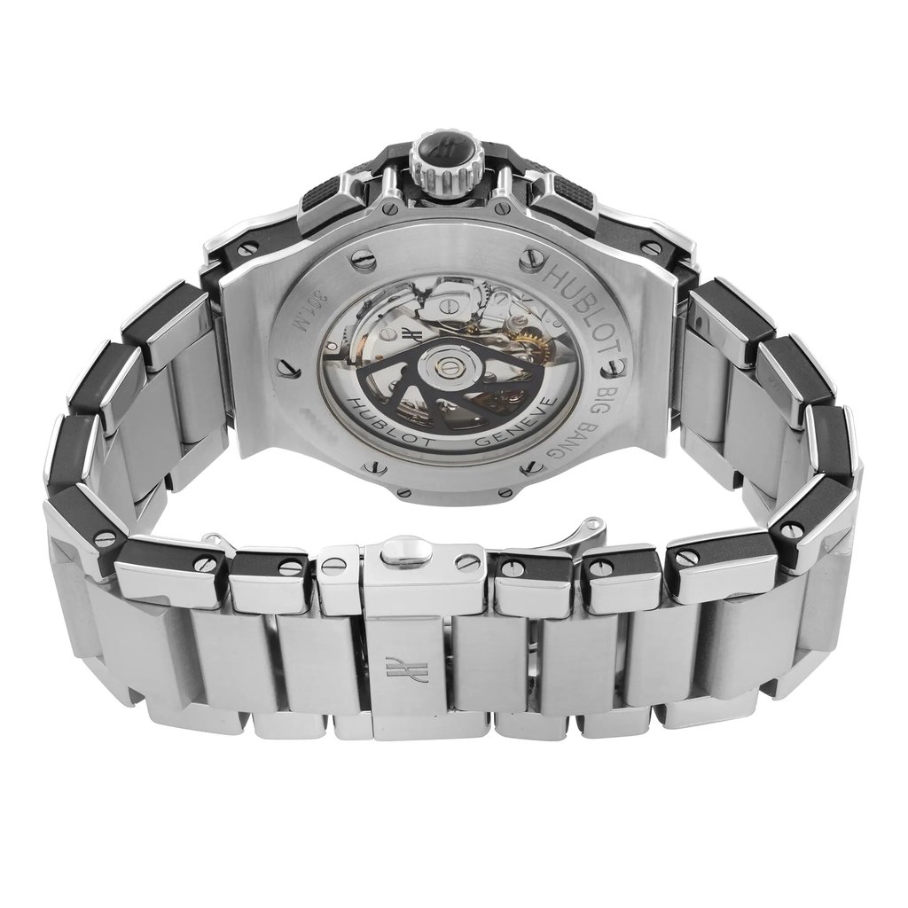 An image of a pre-owned wristwatch taken from the back view, focusing on the open clasp. The watch features a stainless steel bracelet and showcases the intricate inner workings through a transparent case back. The angle is slightly elevated, capturing the details of the clasp and the watch’s mechanical components from a close distance.