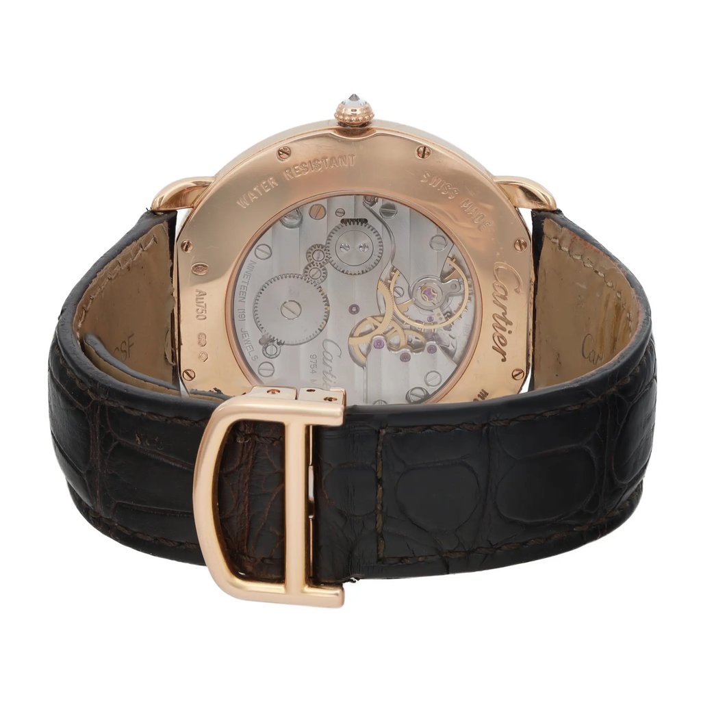 An image of a pre-owned wristwatch captured from the back view, showcasing the intricate internal mechanisms through a transparent case. The clasp is prominently displayed in the foreground, positioned upright, with a close-up angle that highlights the details of the watch's craftsmanship. The strap features a textured, dark leather design.