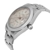 An image of a pre-owned wristwatch viewed from the side profile, showcasing the detailed crown. The watch features a metallic band and a light-colored dial with visible hour markers and hands. The angle highlights the watch face and bracelet, emphasizing the sleek design and craftsmanship.