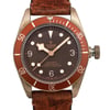 An image of a Wristwatch by TUDOR. This Pre Owned item is designed for Men, featuring a Luxury style. It has a Mechanical (Automatic) movement and an Analog display with a Brown dial color. The indices include 12-Hour Dial,Arabic Numerals,Round Indexes. The band is made of Leather and the case is made of Bronze. The watch has a Round shape with a case size of 43 mm and a case thickness of 15 mm.