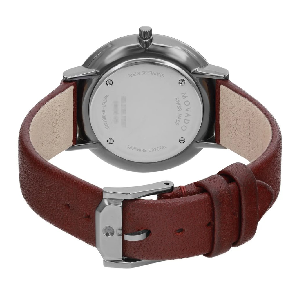 An image of a pre-owned wristwatch viewed from the back, showing a close-up of the closed clasp. The watch has a stainless steel back with inscriptions and a brown leather strap. The shot is taken from a slightly elevated angle, focusing on the details of the clasp and strap at a close distance.