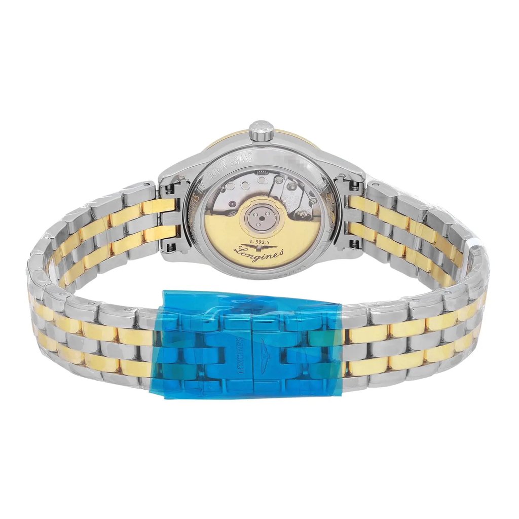 An image of a new wristwatch viewed from the back, highlighting the close clasp. The watch features a silver and gold-toned metal bracelet. The focus is on the transparent case back, showcasing the mechanical movement inside, with protective blue plastic covering the clasp area. The angle is straight-on, capturing the watch at a close distance to emphasize the details.