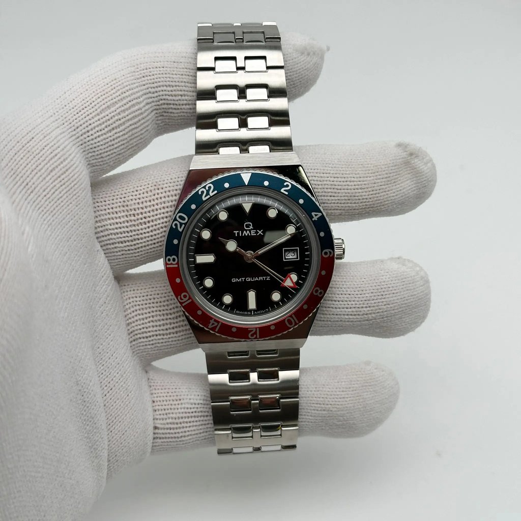An image of a Wristwatch by Timex. This Display Model item is designed for Men, featuring a Casual style. It has a Quartz movement and an Analog display with a Black dial color. The indices include 12-Hour Dial,Round Indexes. The band is made of Stainless Steel and the case is made of Stainless Steel. The watch has a Round shape with a case size of 38 mm and a case thickness of 12.5 mm.