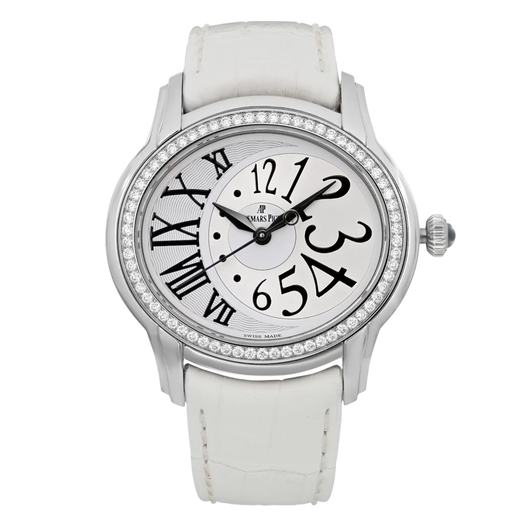 An image of a pre-owned Audemars Piguet Millenary 39mm Steel Diamond Silver Dialwomen's wristwatch. The watch is positioned centrally, facing forward, showcasing its round face and intricate details. The dial features a mix of large Arabic and Roman numerals, with a decorative pattern on the left side. The bezel is adorned with a row of sparkling diamonds, enhancing its elegant appearance. The watch strap is white, complementing the silver-tone case. The image is taken from a close-up angle, capturing the watch's design and craftsmanship.