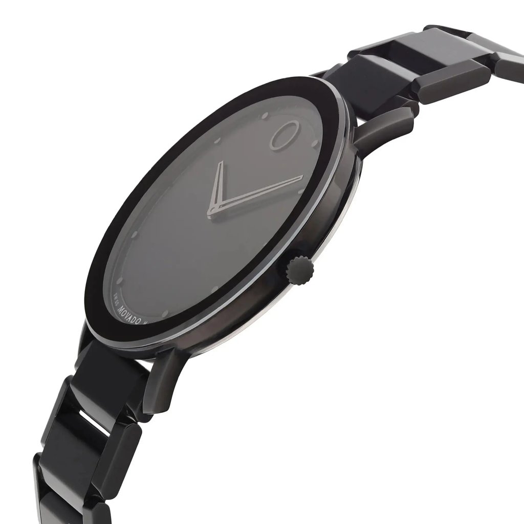 An image of a wristwatch from a side profile view, showcasing its sleek black design. The crown is prominently visible on the right side of the watch's case. The watch has a minimalist face with simple hour markers and a smooth black metal bracelet. The angle highlights the thinness of the case and the polished links of the bracelet, emphasizing its modern aesthetic.