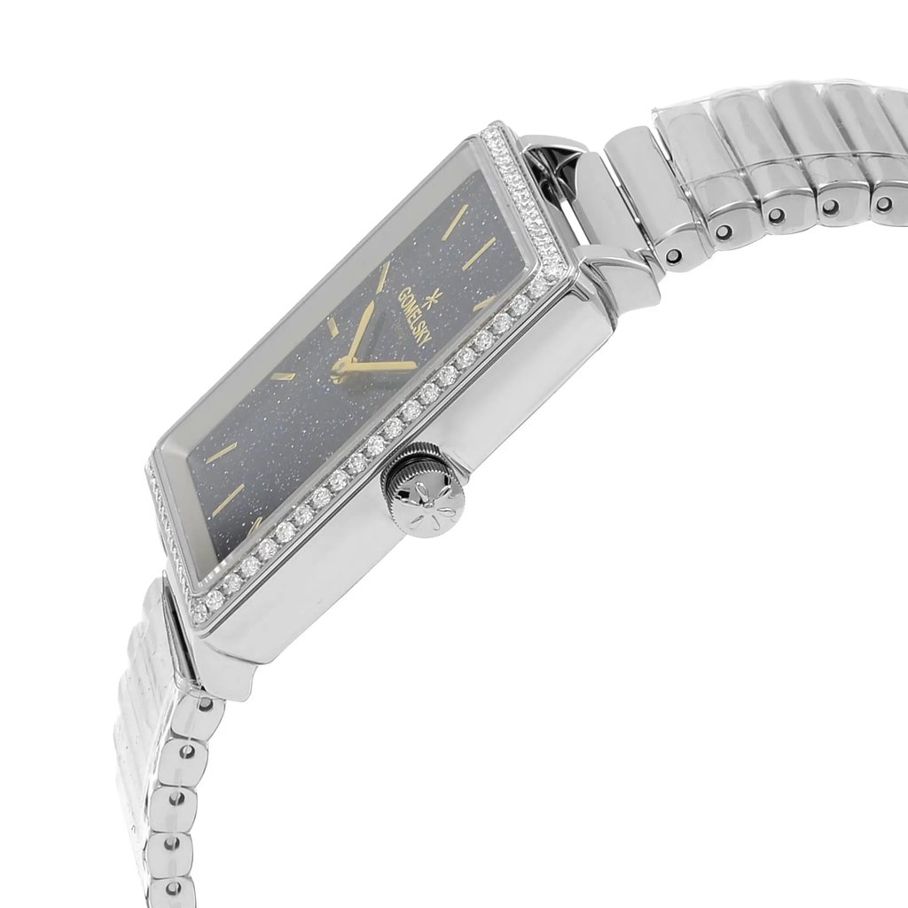 An image of a wristwatch viewed from a side profile angle, highlighting the crown. The watch appears unworn and features a rectangular face with a sparkling dark dial and gold hour markers. The casing is adorned with small stones around the bezel, and the metal bracelet is visible, showcasing its polished links. The image captures the watch from a close distance, emphasizing its sleek and elegant design.