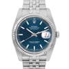 An image of a pre-owned wristwatch captured from a front close-up angle. The watch features a blue dial with silver hour markers and hands. The brand name and model details are visible on the watch face, along with a date display magnified at the 3 o'clock position. The bezel is fluted, and the metal bracelet is partially visible at the top and bottom.