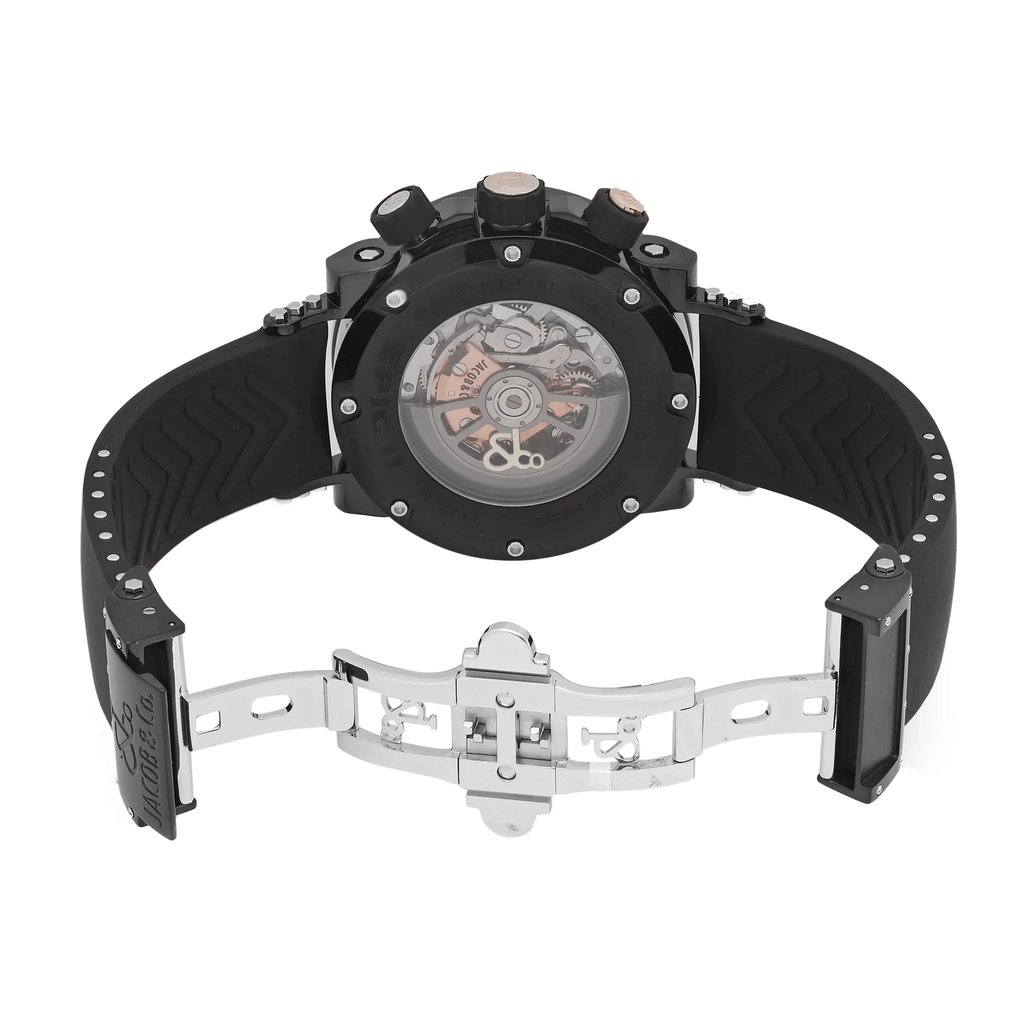 An image of a pre-owned wristwatch, showcasing the back view with an open clasp. The watch is positioned centrally, with the angle highlighting the mechanical inner workings visible through the transparent case back. The black strap is partially extended, and the metallic clasp is open, displaying its intricate design. The photograph is taken from a close distance, providing a detailed view of the watch's components.