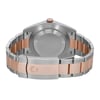 An image of a men's Rolex wristwatch, displayed as a back view with a close clasp. The watch is shown from a direct rear angle and occupies the central portion of the image. Its case material is stainless steel with a screwback design, and the band is made of alternating links of rose gold and stainless steel. The round shape of the watch case is visible, and the fold-over clasp is securely fastened. The photograph appears to be a close-up, highlighting the watch's details and surface textures. The condition is that of a display model, indicating no signs of wear.