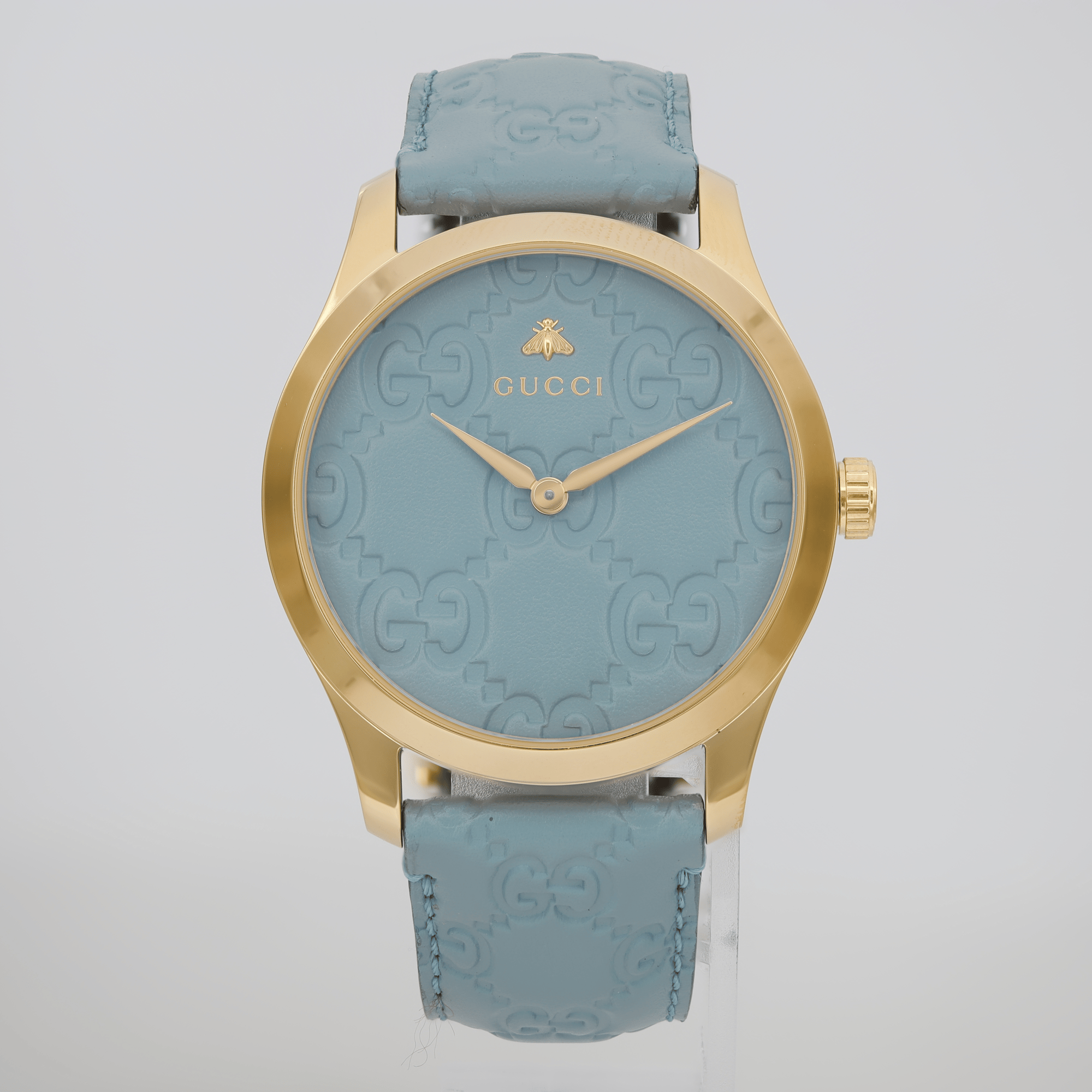 An image of a Wristwatch by Gucci. This Unworn item is designed for Women, featuring a Dress/Formal style. It has a Quartz movement and an Analog display with a Blue dial color. The indices include 12-Hour Dial,No Hour Marks. The band is made of Gold Plated,Stainless Steel and the case is made of Gold Plated,Stainless Steel. The watch has a Round shape with a case size of 38 mm and a case thickness of 9 mm.