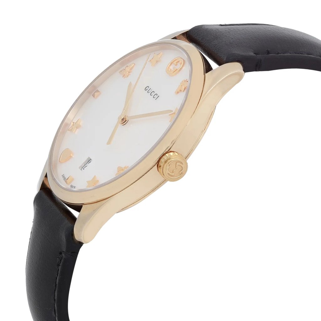 An image of a pre-owned Gucci women's wristwatch in a dress/formal style, shown in a close-up side profile view that highlights the crown. The watch has a round shape with a mother of pearl dial featuring a white background and gold accents. The bezel is gold-colored, and the band is made of black leather. Stainless steel is used for the case material, and the watch features a date indicator. The position and angle showcase the side of the watch, emphasizing the crown's detail and the curvature of the case.