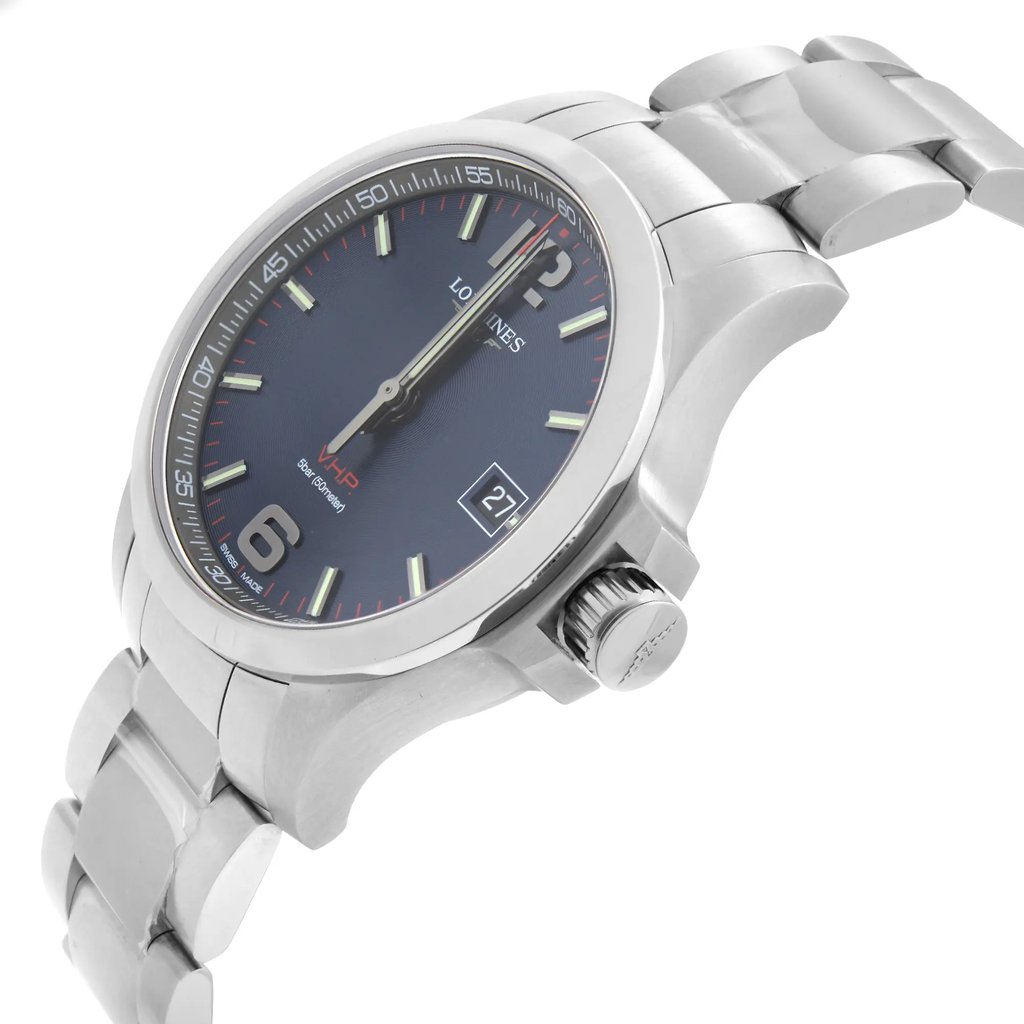 An image of a wristwatch in a side profile view, focusing on the crown, which is prominently displayed. The watch is a display model, showcasing a metallic band and a dark face with visible hour markers and hands. The angle highlights the curvature of the band and the polished finish of the case, captured from a close distance.