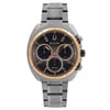 An image of a pre-owned Bulova men's wristwatch in excellent condition, presented in a full frontal view. The watch features a round stainless steel case with a rose gold-tone bezel and a gray dial. It has non-numeric hour marks and stick indexes, along with luminous hands. There are three subdials for chronograph functions and a small seconds subdial, all positioned on the dial. The stainless steel band is attached at both sides of the case, providing a casual yet dress/formal style. The watch is photographed from the front at a close distance, allowing clear visibility of its features and the "Bulova" brand name on the dial.