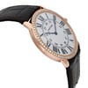 An image of a pre-owned wristwatch taken from a side profile view opposite the crown. The watch features a round face adorned with Roman numerals and is encircled by a diamond-studded bezel. The case is made of a rose gold-colored metal, and the band is a textured black leather strap. The angle and distance highlight the watch’s elegant design and luxurious details.