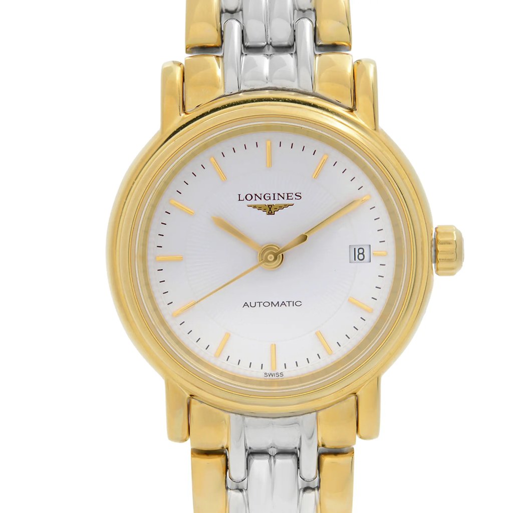 An image of a wristwatch captured in a front close-up shot, focusing on the watch face. The timepiece is a display model with a gold bezel and a silver and gold bracelet. The dial is white with gold hour markers and hands, featuring a date display at the 3 o'clock position. The brand name is visible on the upper half of the dial.