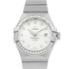 An image of a women's OMEGA wristwatch, viewed from a straight-on angle at a close distance. The watch features a silver bracelet and a round face with diamond hour markers. The bezel is encrusted with small diamonds, and the date is displayed at the 3 o'clock position. The watch face is white with the brand name "OMEGA" and "Constellation" inscribed on it.