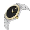 An image of a pre-owned wristwatch, shown in a front close-up shot of the watch face. The watch features a minimalist black dial with two gold hands and a gold dot at the 12 o'clock position. It has a gold bezel and a stainless steel band, with the crown positioned on the right side. The angle captures the watch from a slightly elevated perspective, emphasizing its sleek design.