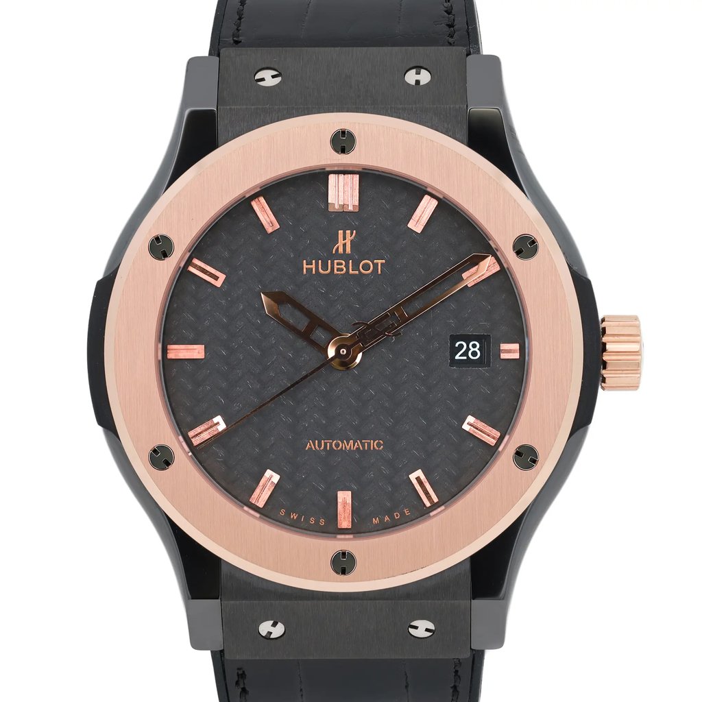 An image of a pre-owned Hublot men's wristwatch shown from the front at a close-up angle. The watch features a dark textured dial with rose gold-tone hour markers and hands. The date indicator is positioned at the 3 o'clock mark. The case is accented with rose gold and the crown is on the right side. The black strap is partially visible at the top and bottom.