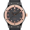 An image of a pre-owned Hublot men's wristwatch shown from the front at a close-up angle. The watch features a dark textured dial with rose gold-tone hour markers and hands. The date indicator is positioned at the 3 o'clock mark. The case is accented with rose gold and the crown is on the right side. The black strap is partially visible at the top and bottom.