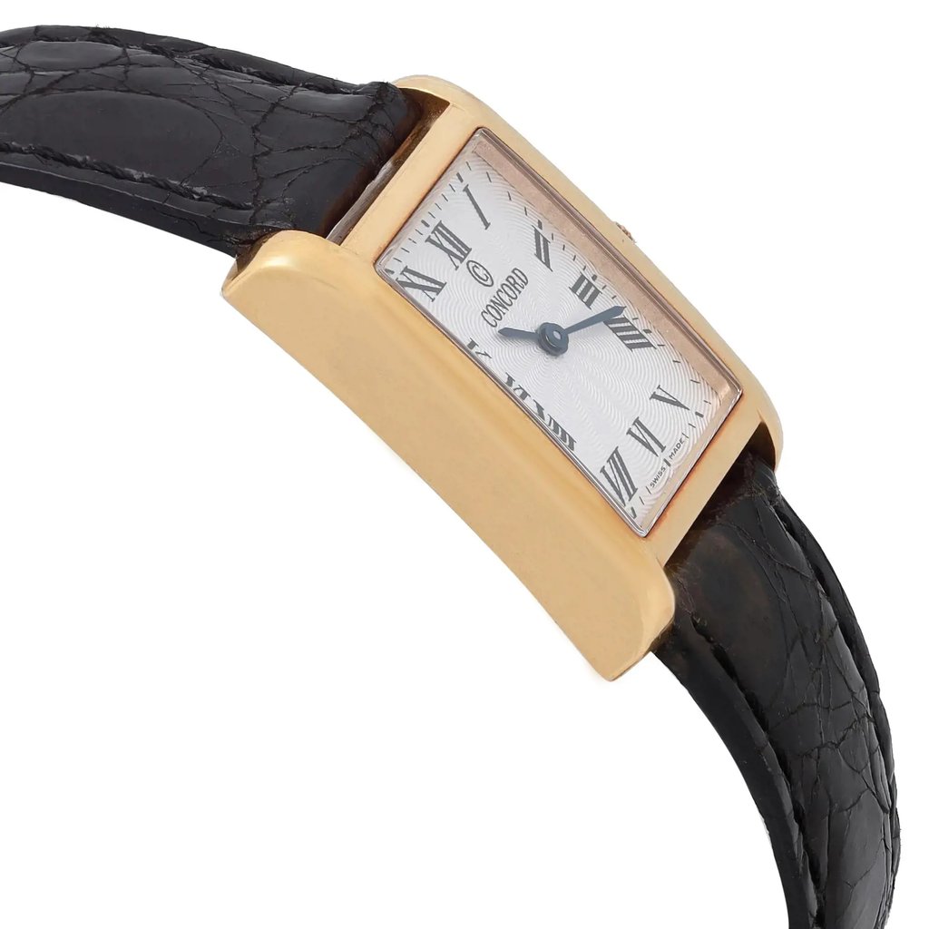 An image of a pre-owned wristwatch taken from a side profile view opposite the crown, showcasing its rectangular gold-toned case and black leather strap. The watch face features Roman numerals and blue hands, viewed at a slight angle to highlight the details. The image is taken at a close distance to emphasize the watch's design elements.