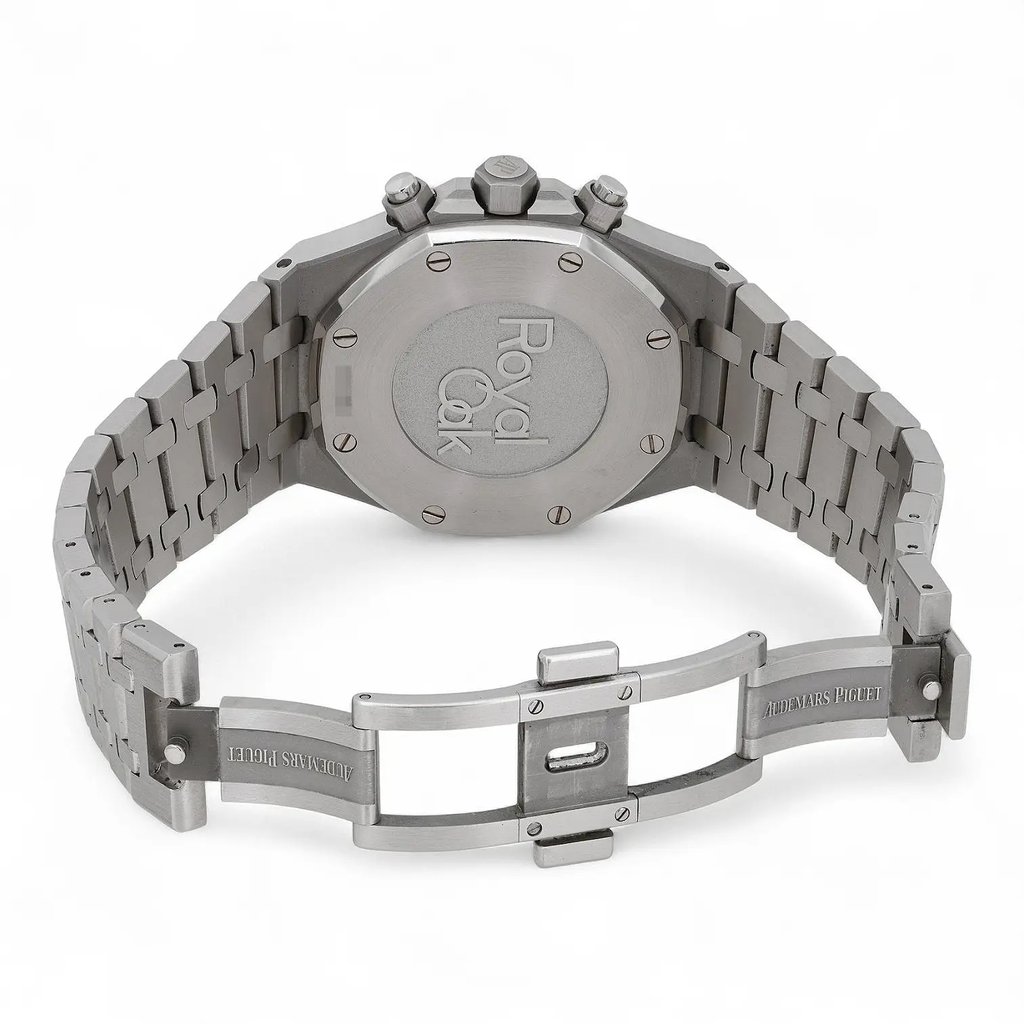 An image of a pre-owned men's Audemars Piguet wristwatch taken from a rear angle, showcasing the closed stainless steel bracelet and the back of the watch case. The watch is positioned upright, with the bracelet slightly curved to display the engraved brand name "Audemars Piguet" on the clasp. The image is captured at a medium distance, highlighting the watch's intricate metalwork and the "Royal Oak" engraving on the back.