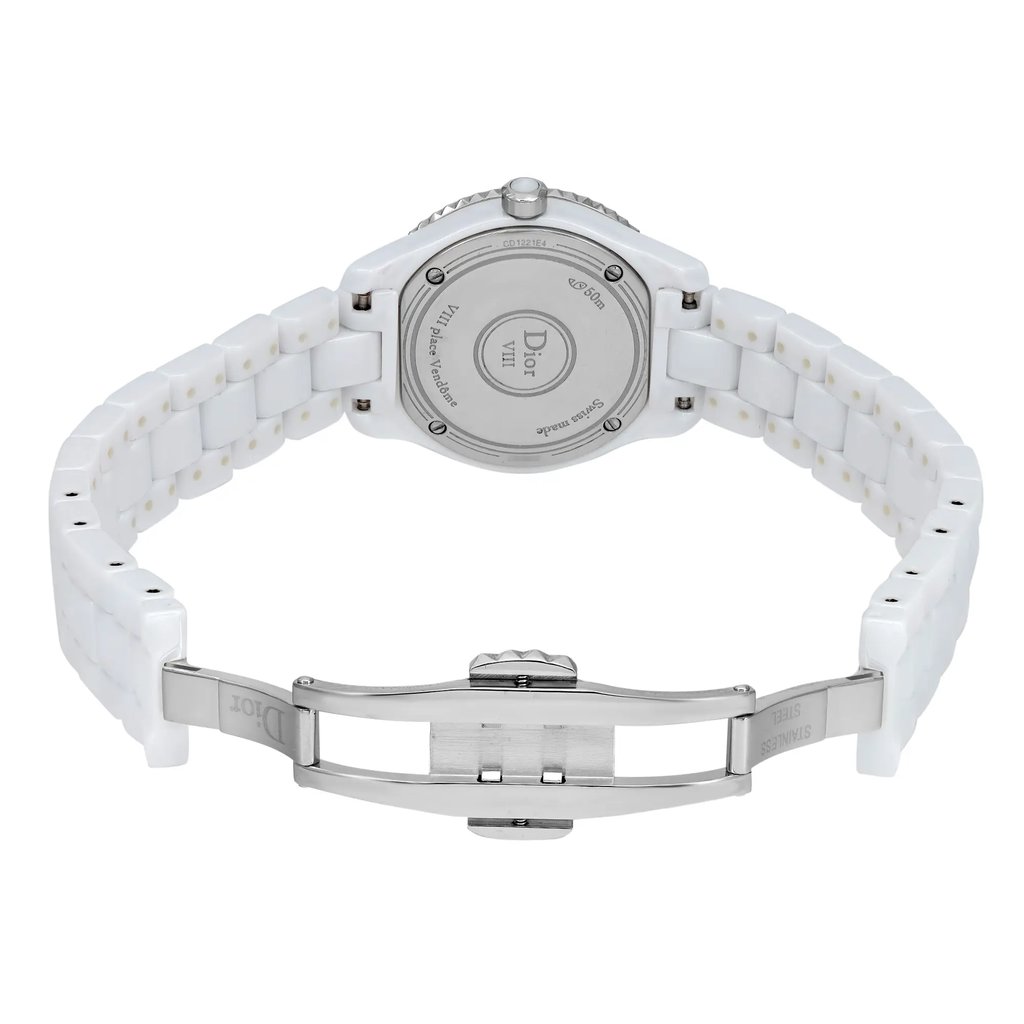 An image of a pre-owned wristwatch shown from the back view. The focus is on the open clasp, revealing the brand's logo and inscriptions on the back of the case. The watch features a white ceramic bracelet and a stainless steel clasp. The shot is taken from a straight angle at a moderate distance, highlighting the details of the clasp and bracelet links.