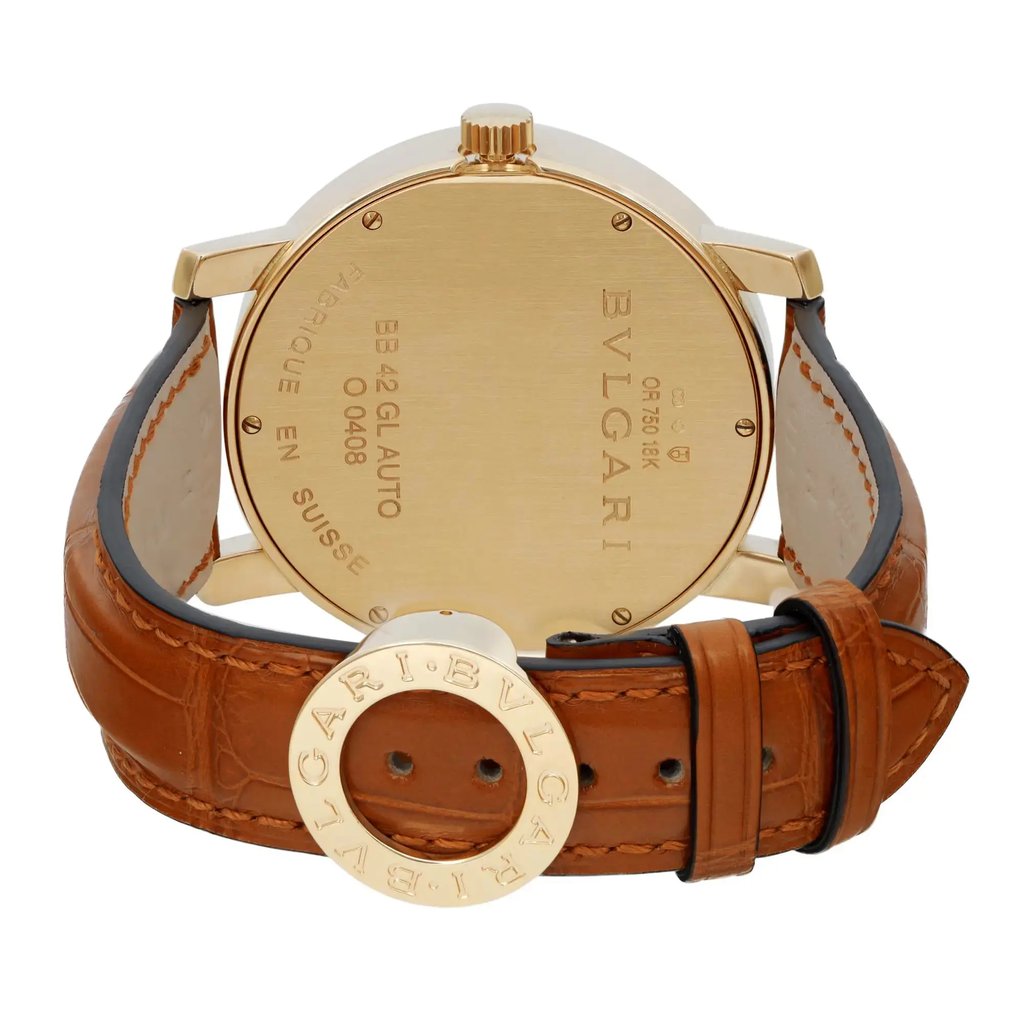 An image of a pre-owned men's Bvlgari wristwatch captured from the back at a close angle. The watch features a yellow gold case and a brown leather strap. The back of the watch displays engraved details, including the brand name and other specifications. The watch is positioned upright, showcasing its leather strap and metal clasp.