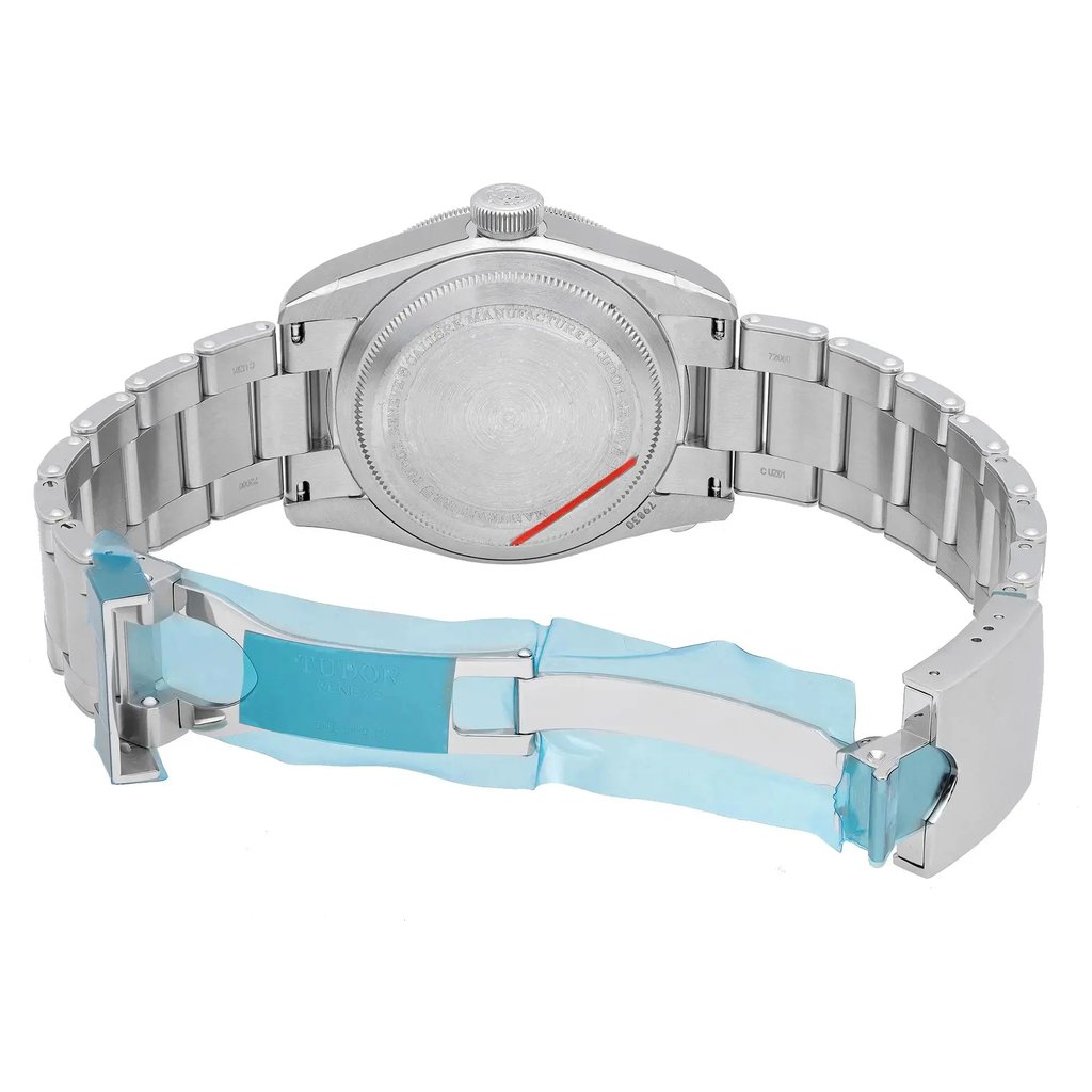 An image of an unworn TUDOR men's wristwatch, viewed from the back with the clasp open. The watch features a solid stainless steel caseback and a stainless steel band. The round case and fold-over clasp with flip lock safety are clearly visible. The watch includes features such as a date indicator, GMT, and luminous hands. The angle is direct and close, showcasing the details of the back and clasp.