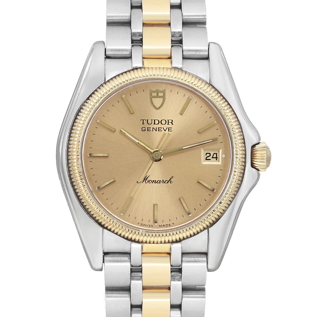 An image of a pre-owned men's TUDOR wristwatch, viewed from the front at a close angle. The watch features a two-tone metal bracelet, a gold-toned face with a date indicator at the 3 o'clock position, and luminous hands. The brand name and emblem are prominently displayed on the dial.