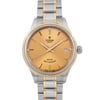 An image of a wristwatch showcasing a front close-up view of the watch face. The watch features a gold-colored dial with silver and gold-tone hour markers and hands. The date is displayed on the right side. The bezel is gold-toned, and the bracelet has a combination of stainless steel and gold links. The watch is in unworn condition.
