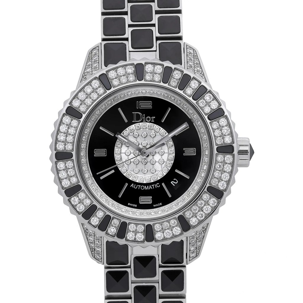 An image of a wristwatch taken from a front close-up angle, showcasing the watch face. The timepiece features a black dial with silver-toned hands and diamond accents. The bezel and bracelet are adorned with alternating black and diamond-patterned segments, adding a luxurious touch. The watch is a display model.