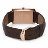 An image of a pre-owned Piaget men's wristwatch, viewed from the back. The watch is positioned upright, showcasing its rectangular rose gold case back with engraved details. The brown leather strap is visible, with a focus on the rose gold clasp, which is partially open. The angle is slightly elevated, capturing the watch at a medium distance, highlighting the craftsmanship and materials.