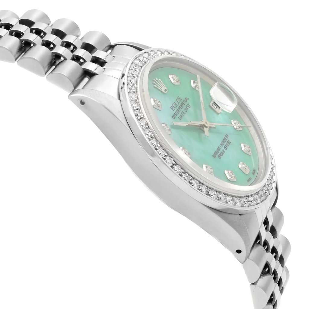 An image of a pre-owned wristwatch captured from a side profile view, opposite the crown. The watch features a silver metal case and a bracelet with a polished finish. The dial is a vibrant turquoise with diamond hour markers, encircled by a diamond-studded bezel. The photograph is taken at a close angle, highlighting the intricate details and craftsmanship of the watch.