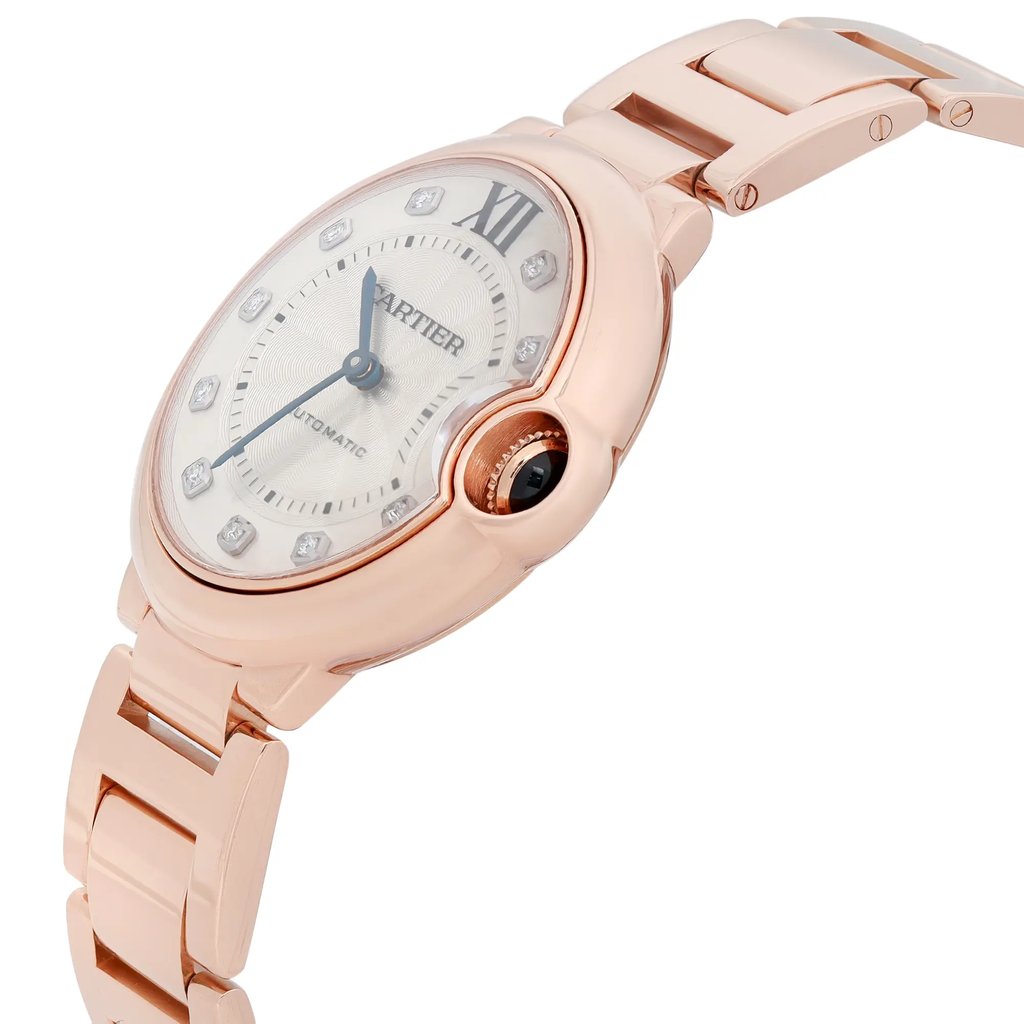 An image of a pre-owned Cartier luxury wristwatch for women shown in a side profile view with the crown visible. The watch features a round shape with a silver dial that has a diamond hour markers, and Roman Numeral for the 12'Oclock indice . The bezel and band are made of rose gold, and the watch is positioned at a slight angle, with the top of the watch tilted away from the viewer, providing a clear view of the side and part of the bracelet. The image is taken from a close distance, focusing on the watch's details and craftsmanship.