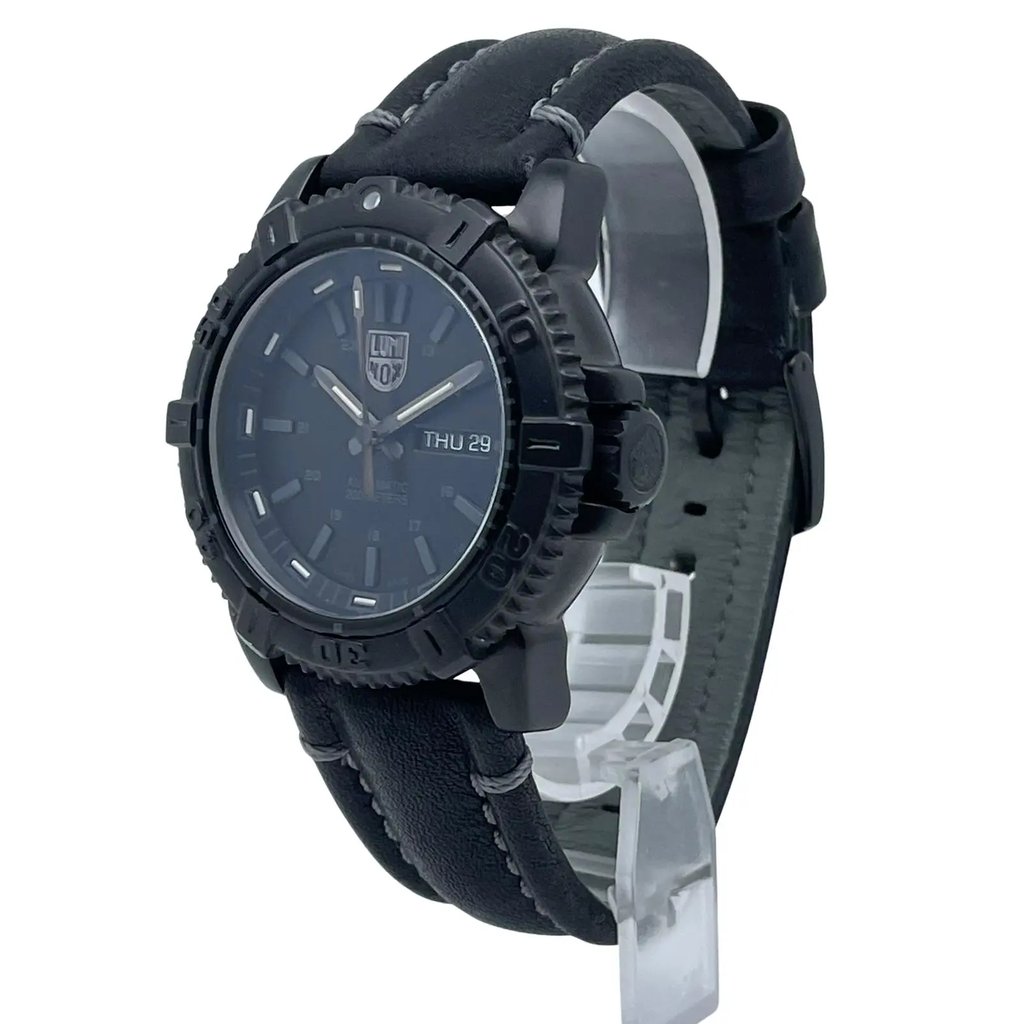 An image of a Wristwatch by Luminox. This Pre Owned item is designed for Men, featuring a Casual,Diver style. It has a Mechanical (Automatic) movement and an Analog display with a Black dial color. The indices include 12-Hour Dial,Non-Numeric Hour Marks,Stick Indexes. The band is made of Leather and the case is made of Stainless Steel. The watch has a Round shape with a case size of 45 mm and a case thickness of 14 mm.