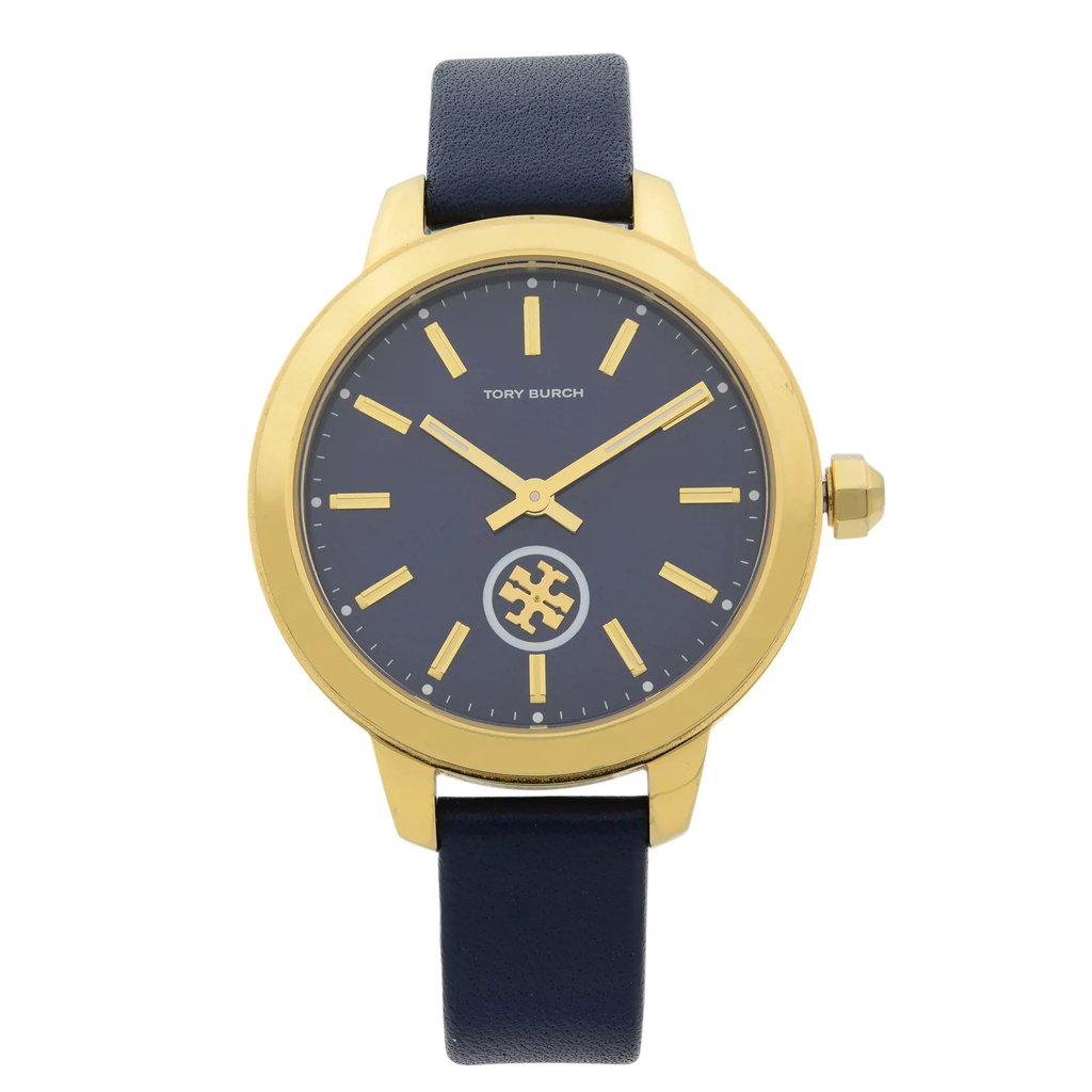 An image of a Wristwatch by Tory Burch. This Pre Owned item is designed for Women, featuring a Dress/Formal style. It has a Quartz movement and an Analog display with a Blue dial color. The indices include 12-Hour Dial,Non-Numeric Hour Marks,Stick Indexes. The band is made of Leather and the case is made of Stainless Steel. The watch has a Round shape with a case size of 38 mm and a case thickness of 9 mm.
