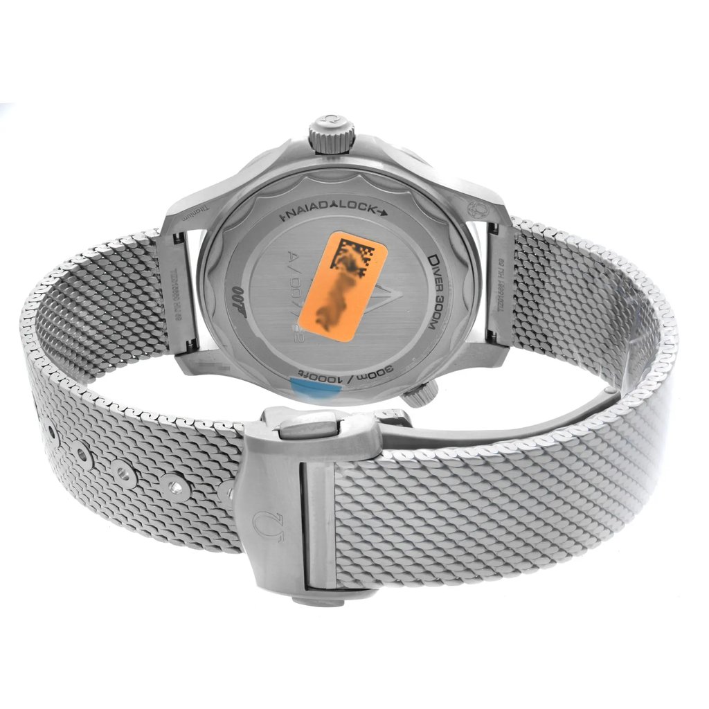 An image of a men's OMEGA wristwatch, displaying the back view with the clasp closed. The watch is a display model with a titanium case and band, showcasing a solid caseback and a round shape. The titanium band features a fold-over clasp with double push buttons. The watch is positioned upright at a perpendicular angle to the camera, providing a clear view of the caseback and band details. The image is taken from a close distance, ensuring all intricate details are visible.