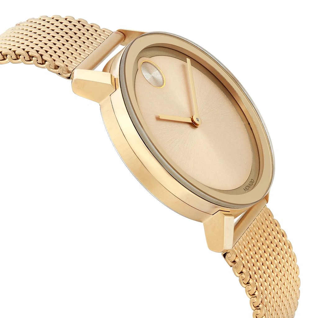 An image of a pre-owned wristwatch captured from a side profile view, opposite of the crown. The watch features a gold mesh band and a minimalist gold dial with sleek hands. The angle highlights the watch's smooth bezel and elegant design, offering a close-up perspective of its craftsmanship.
