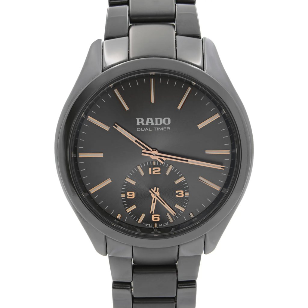 An image of a wristwatch shown in a front close-up shot, focusing on the watch face. The watch is in display model condition, with a sleek, dark metallic band. The face features a dual timer with gold-tone hour markers and hands, displaying a modern and sophisticated design.