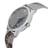 An image of a new, unworn Gucci wristwatch for unisex adults showcased from a side profile view with the crown visible. The watch, captured at a close distance, features a round stainless steel case and a stainless steel band with a distinctive animal print pattern on the silver dial. The brand's logo is subtly displayed at the center top of the dial. The photo angle presents the watch in a way that highlights the watch's shape and design details, including the texture of the band and the sleekness of the case.