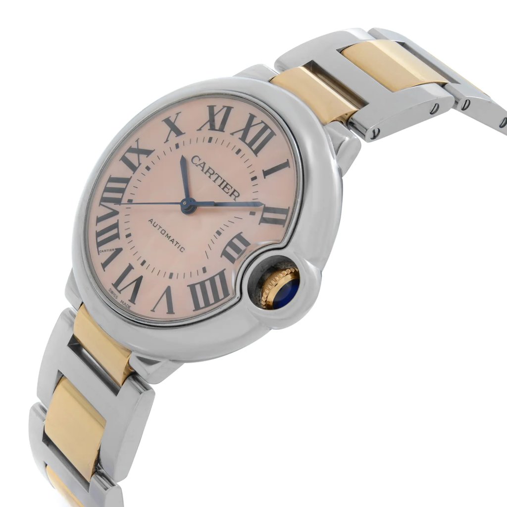 An image of a pre-owned wristwatch shown from a side profile view, highlighting the crown. The watch features a round face with Roman numerals and a two-tone metal bracelet. The angle showcases the elegant curvature of the watch case and the distinctive crown detail. The image is taken at a close distance, capturing the intricate details of the watch design.