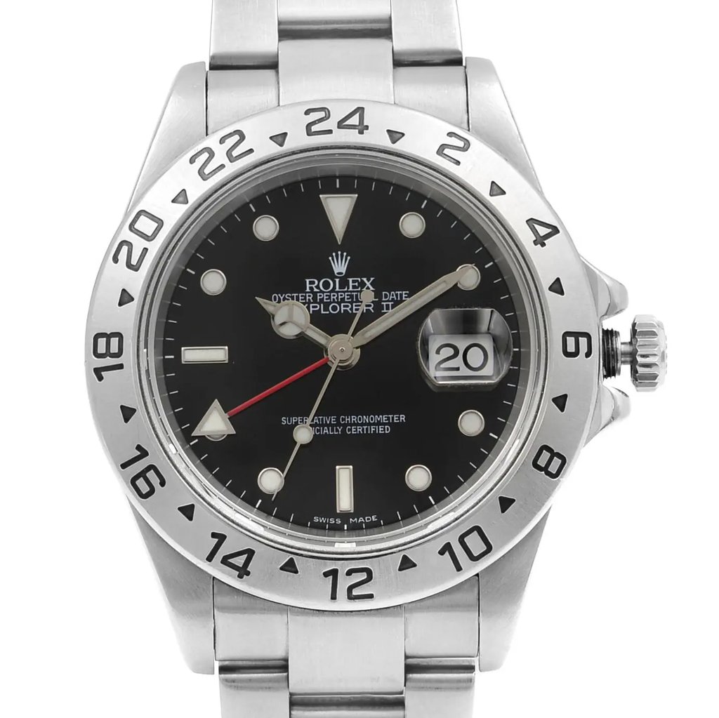 An image of a pre-owned wristwatch captured in a close-up front shot, showcasing the watch face prominently. The watch features a silver stainless steel bezel and bracelet, with a black dial. The hour markers are luminous, and there's a date window magnified at the 3 o'clock position. The watch hands are luminescent with a red additional hand for the 24-hour time display. The crown is visible on the right side of the watch.