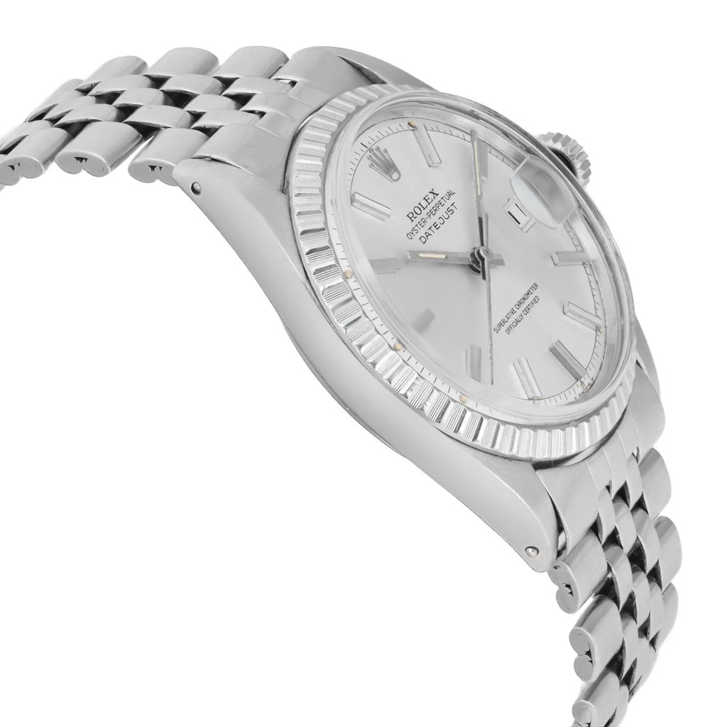 An image of a pre-owned wristwatch shown from a side profile view, opposite the crown. The watch features a silver metal bracelet and a silver-toned dial with baton hour markers. The image captures the watch at a slight angle, highlighting its sleek, polished finish and intricate details. The focus is close, emphasizing the design and craftsmanship of the timepiece.