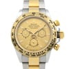 An image of a pre-owned men's luxury Rolex wristwatch, captured from a front close-up angle focusing on the watch face. The dial is champagne-colored, featuring a chronograph with luminous hands and stick indexes. The bezel is gold, complementing the stainless steel and yellow gold band. The round case is made of stainless steel, and the watch includes features like a small seconds subdial. The overall condition is classified as good.