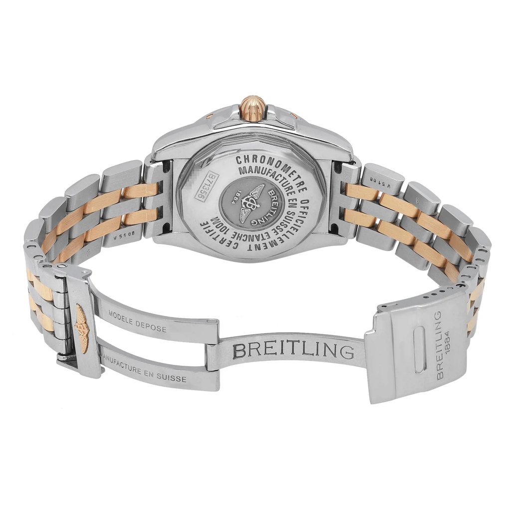An image of a pre-owned Breitling women's wristwatch in a back view with an open clasp. The round watch case and band are made of stainless steel with yellow gold accents. The screwback caseback features engraved branding and details, and the band has a fold-over clasp with flip lock safety. The watch is positioned at a slight angle, with its left side slightly lifted, offering a clear view of the caseback and band, filling the frame from a medium distance. The watch is pre-owned and may show minor signs of wear.