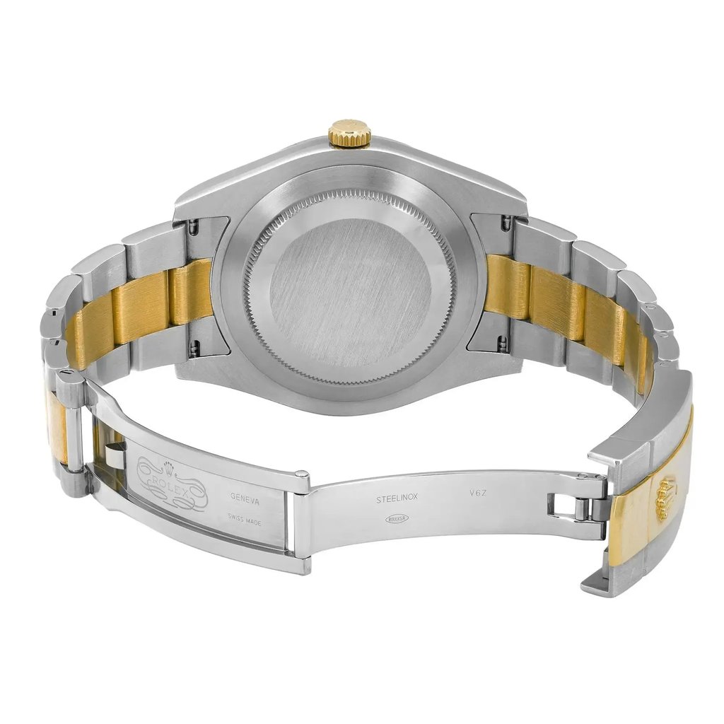 An image of a pre-owned Rolex men's wristwatch, shown from the back with an open clasp. The watch is positioned at a slight angle, with the top of the watch facing slightly to the left and the clasp open towards the right, giving a clear view of the caseback and interior of the bracelet. The case and caseback are made of stainless steel with a screwback design, and the bracelet combines stainless steel and yellow gold links. The watch has a round shape and features a fold-over clasp. Minor signs of wear are visible on the surfaces. The image is a close-up, showing the watch in detail and occupying the majority of the frame.