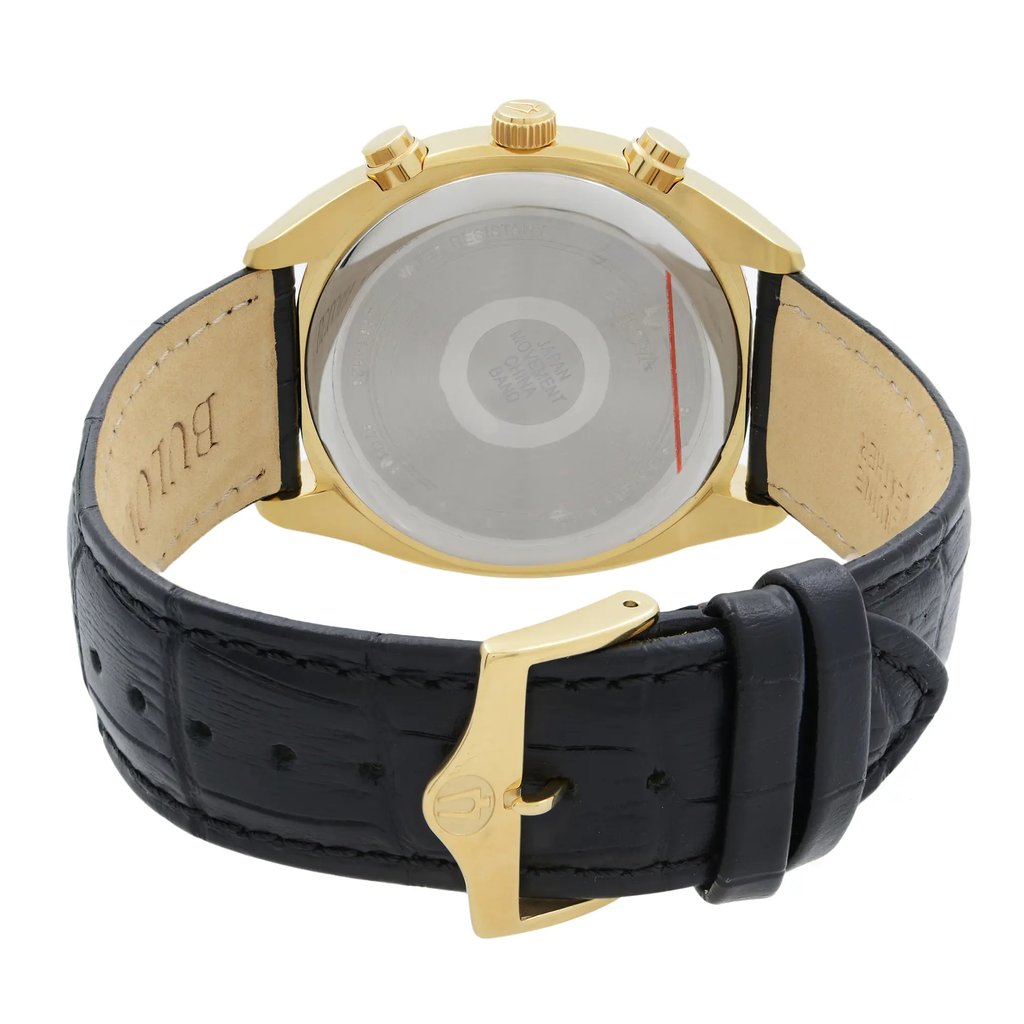 An image of a new Bulova men's wristwatch with defects, viewed from the back showing the solid caseback. The stainless steel case is round, and it is attached to a black leather band with a gold-tone buckle closure. The watch is positioned upside down, with the buckle in the lower foreground and the back of the watch case slightly out of focus towards the upper background. The angle is a close-up, with the inside of the strap visible and the Bulova logo on the buckle clearly visible.