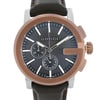 An image of a new Gucci men's dress wristwatch with defects, shown in a front close-up view focusing on the watch face. The watch features a round stainless steel case with a bronze bezel, a black teaked dial, and luminous hands. It includes a chronograph, small seconds subdial, and stick indexes for the 12-hour dial. The band is made of leather. The watch is positioned straight on at a close distance, allowing for clear visibility of details and the Gucci brand name on the dial.