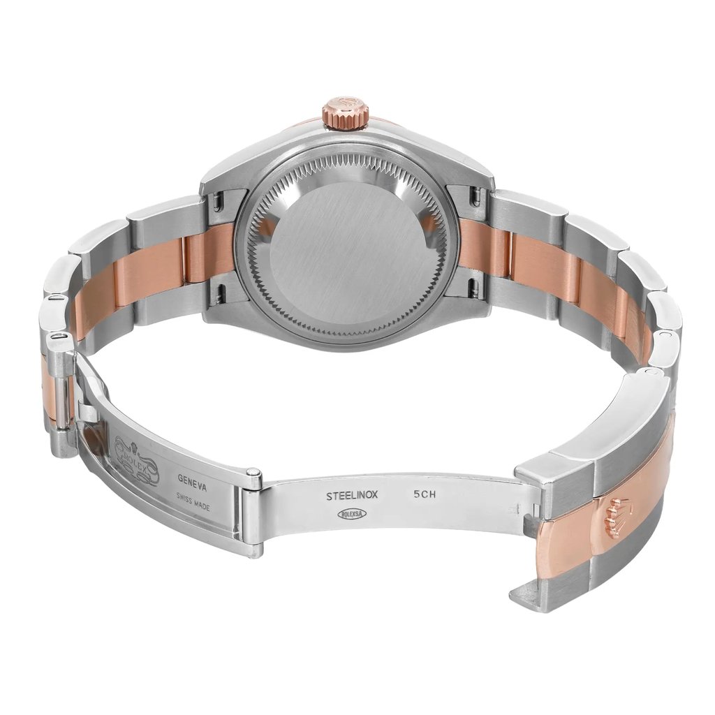 An image of a pre-owned Rolex women's wristwatch, viewed from the back with an open clasp. The watch has a round stainless steel case with a screwback. The band is made of stainless steel and rose gold, featuring a fold-over clasp. The watch is positioned at a slight angle, with the caseback centered and the open clasp bands extending to the upper left and lower right corners of the frame, allowing a clear view of the design and materials. The distance from the camera gives a full view of the watch's back and partial band.